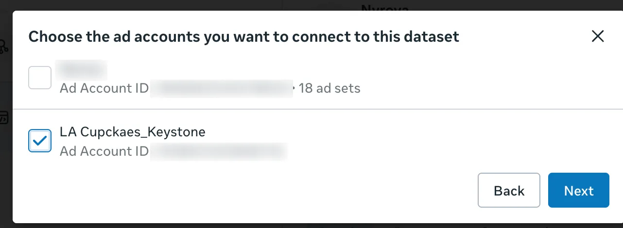 The Choose the ad accounts you want to connect to this dataset dialog with the new LA Cupcakes_Keystone account ticked, with Back and Next buttons. Account IDs are blurred.